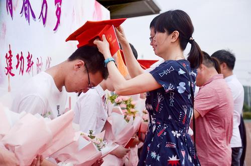 老师为学生配戴成人帽 老师为学生配戴成人帽