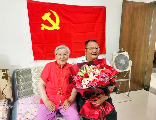 (2)胡希廉老师和邵元辉在党旗下亲切合影 (2)胡希廉老师和邵元辉在党旗下亲切合影
