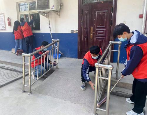 2志愿者们认真擦拭护栏 2志愿者们认真擦拭护栏