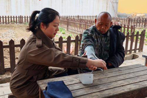 2taptap滚球校红十字社团指导老师周慧敏为老人测量血压 2taptap滚球校红十字社团指导老师周慧敏为老人测量血压